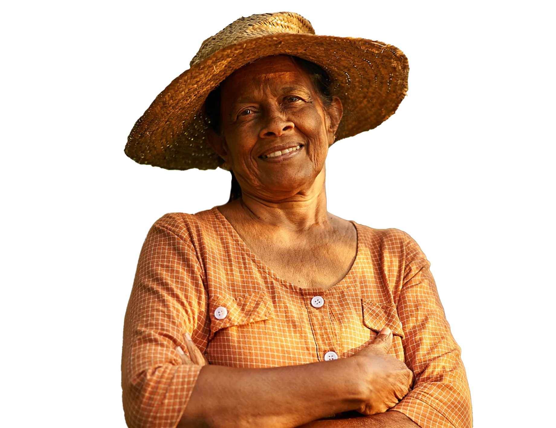 A smiling woman in a straw hat with her arms folded